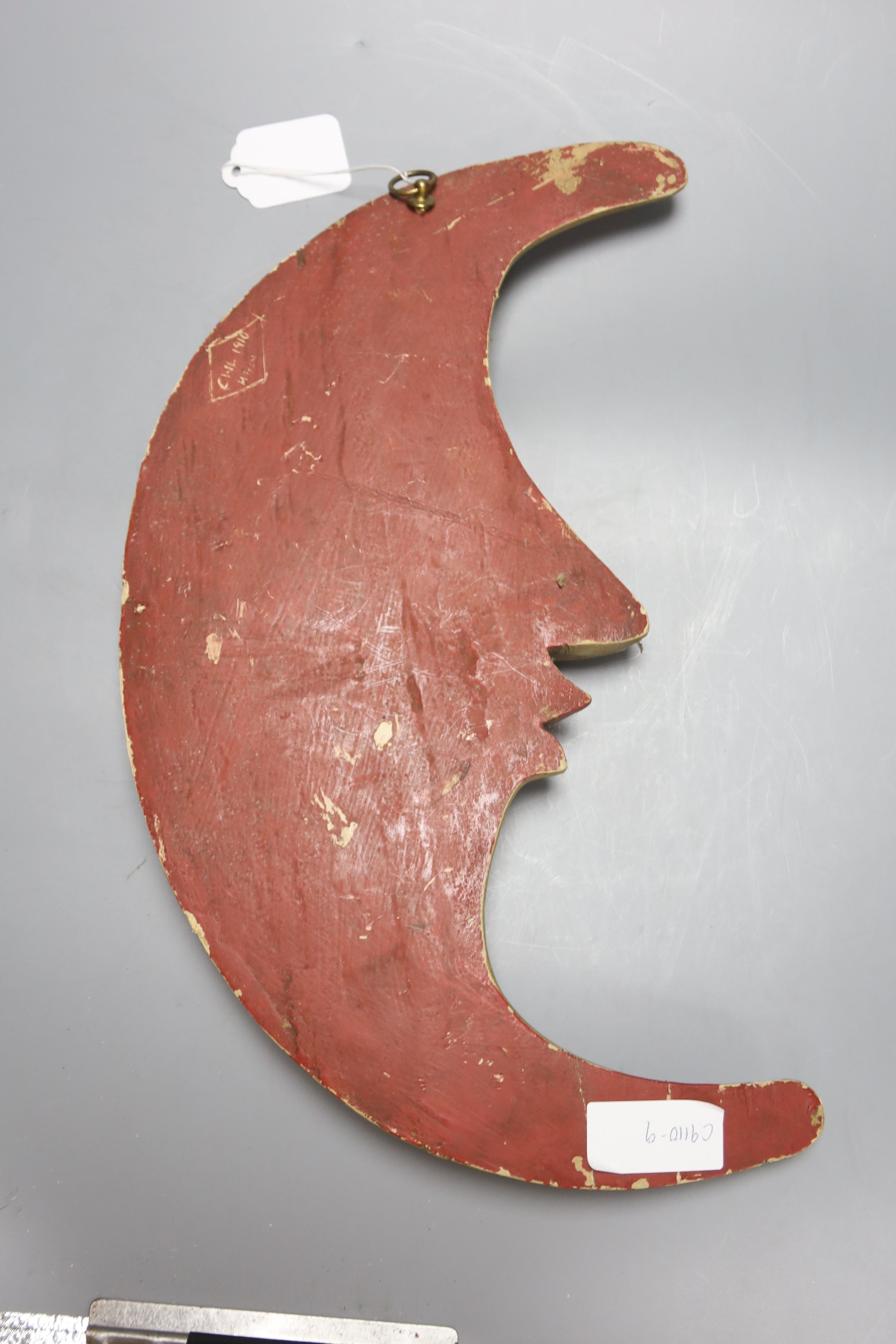 A Continental printed wood crescent Man in the Moon plaque, back inscribed CWL 1910 MAYEN